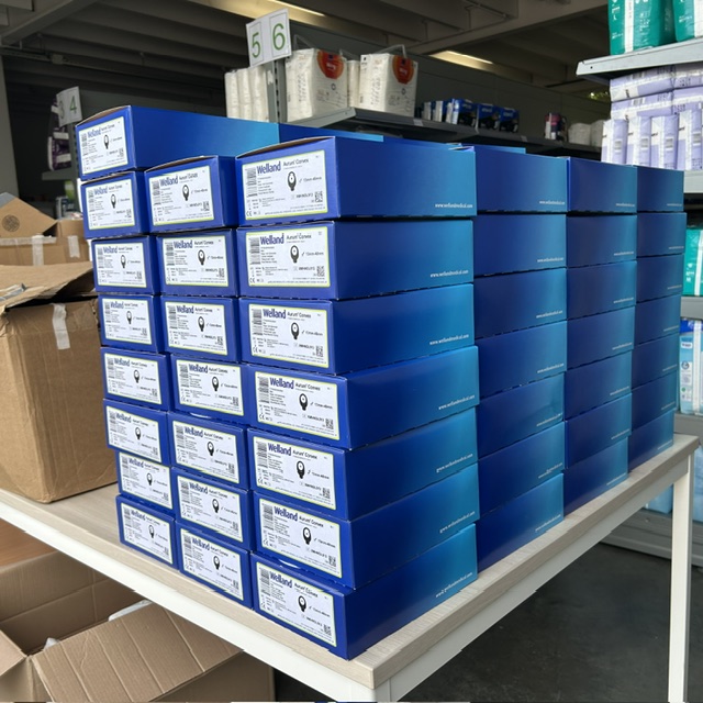 Netjes gestapelde blauwe archiefdozen met medische hulpmiddelen in het magazijn van CareCycle, klaar voor hergebruik of donatie.